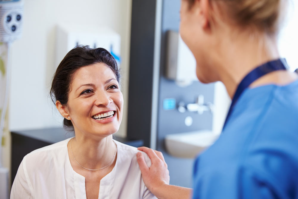 Female Patient talking with Doctor In Hospital
