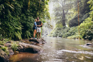 young couple standing together by the creek